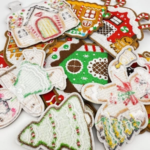 Macro detail of Christmas embroidery patches showing snowman and gingerbread house textures