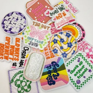 Detailed view of colorful embroidered motivational patches with vibrant flower and butterfly patterns