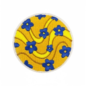 Colorful embroidered flower patch with vibrant yellow base and blue floral design