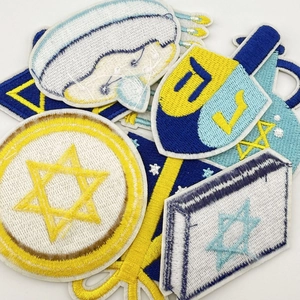 Close-up of Hanukkah embroidery patches with David Star and Dreidel on white background