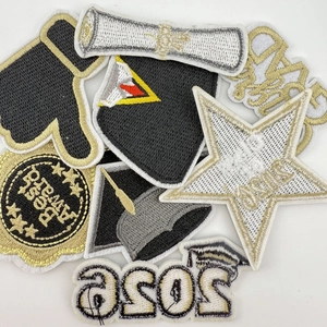 Detailed close-up of premium black and gold graduation-themed embroidered patches for clothing