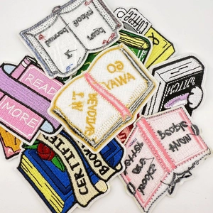 Detail view showing assorted colorful bookworm themed embroidered patches with text