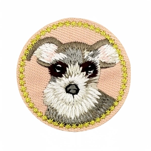 Round embroidered patch with Schnauzer dog pattern and gold stars on pink fabric