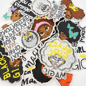 Gros plan de patchs brodés Black Girl Magic montrant les détails des fils et textures