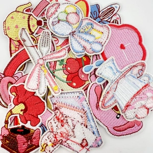 Close-up of pink cartoon bear and flower embroidery patches for clothing and DIY decor