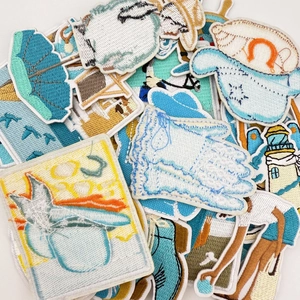 Macro detail of coastal embroidery patches showing high-density stitching and needlework