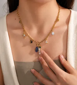 Dettaglio collana a maglie placcata oro 18K con ciondoli a stella e pietre colorate