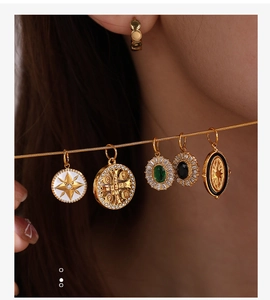 Dettaglio di cinque ciondoli vintage placcati oro con stelle marine e bussole