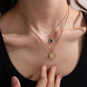 Collana a doppio strato dorata con ciondolo gemma verde e medaglia vintage indossata