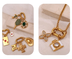 Detailansicht goldener Vintage-Anhänger mit Tennisschläger und smaragdgrünen Steinen