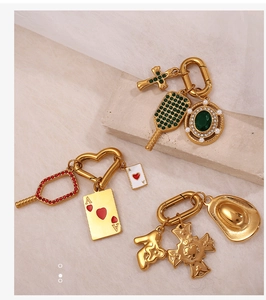 Detailansicht goldener Anhänger mit Strass-Herzverschluss und Spielkarten-Anhänger