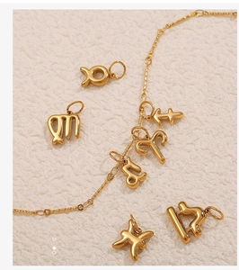 Dettaglio di ciondoli zodiacali placcati oro 18K su una sottile catena dorata elegante