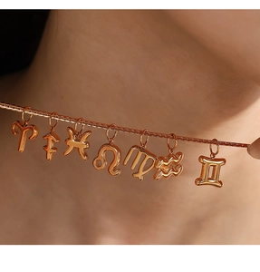 Primo piano della collana in oro rosa 18K con ciondoli dei segni zodiacali lucidi