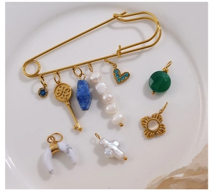 Vue macro détaillée d'une grande broche dorée avec saphirs et pendentifs en perles