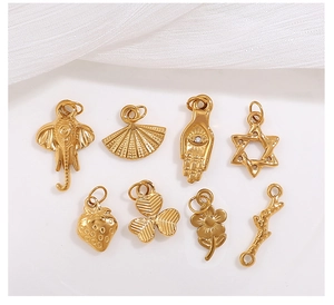 Colgantes DIY bañados en oro de 18 quilates con formas de palma y estrella en tela blanca