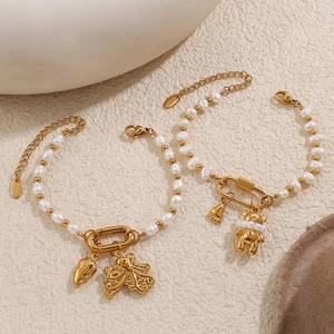 Goldene Edelstahlarmbänder mit Süßwasserperlen sowie Schmetterling- und Bärenanhängern
