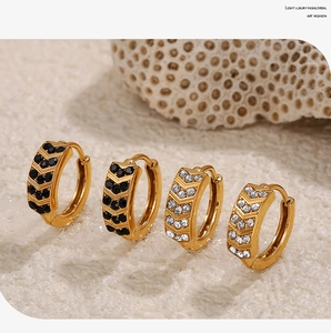 Dettaglio di orecchini a cerchio placcati oro 18K con zirconi neri e bianchi a V