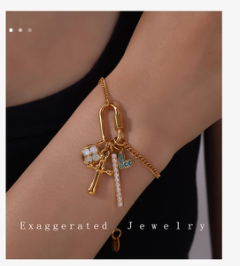 Bracelet à breloques doré avec pierre de cœur bleue et pendentifs de fleurs blanches