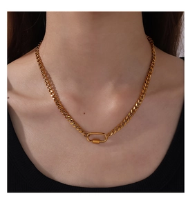 Détail d'un collier chaîne cubaine dorée avec fermoir mousqueton ovale sur le mannequin