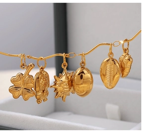 Gros plan de pendentifs plaqués or 18 carats avec motifs de soleil et de trèfle à quatre