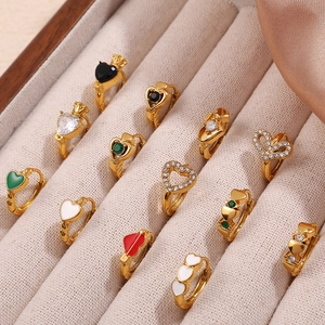 Boucles d'oreilles créoles cœur dorées avec émail et zircon sur un plateau en velours beige
