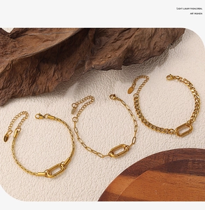 Detailed macro view of three gold-plated stainless steel bracelets with oval link charms