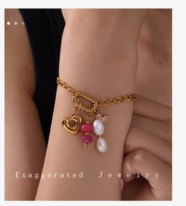 Detail of gold chain bracelet with heart charm, pink beads and white baroque pearls