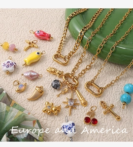 Detail of DIY jewelry charms set with gold chain including heart and cherry pendants