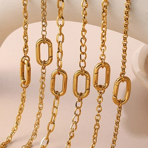 Gold plated stainless steel chains with oval carabiner clasps on beige stone
