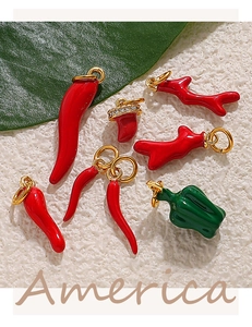 Detalle de colgantes de esmalte con forma de verduras y acabados dorados brillantes