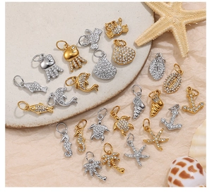 Macro shot of gold and silver sea animal charms with rhinestones on a stone tray