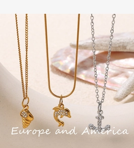 Detailed close-up of gold starfish and anchor pendants with rhinestones on beach theme