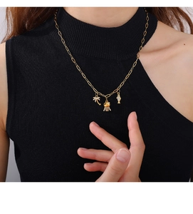 Detail of gold necklace with rhinestone palm tree and ocean pendants on a model