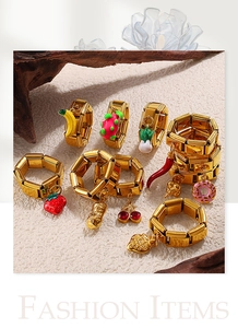 Detail view of 18K gold plated stainless steel charm bracelets with colorful fruit pendants