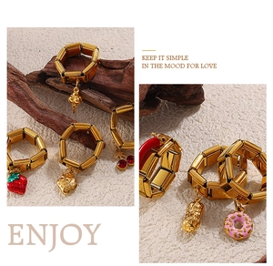 Detail of gold-plated stainless steel charm rings with strawberry and heart pendants