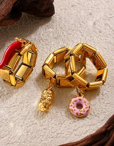 Macro detail of 18K gold plated stretch rings featuring chili, peanut and donut charms