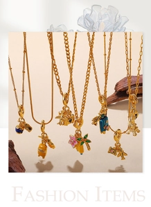 Macro view of gold-plated travel-themed charms with colorful enamel and assorted chains
