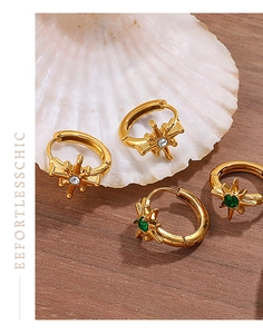 Detail von 18K Gold Stern-Creolen mit grünen und weißen Kristallen auf einer Muschel
