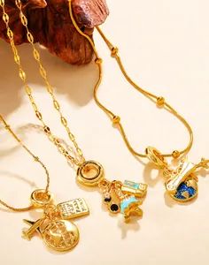 Detailed view of gold travel-themed necklaces featuring plane, globe, and passport charms