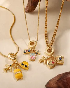 Close-up of gold layered travel necklaces featuring airplane, suitcase and camera charms