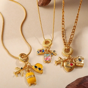 Travel themed gold necklaces with colorful airplane and suitcase charms for women