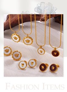 Detail of 18K gold-plated necklace and earrings set with bee and heart motifs