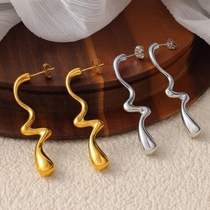 Boucles d'oreilles vagues abstraites plaquées or et argent sur support en bois