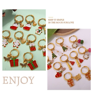 Detailed view of Christmas tree and gingerbread man charms on 18K gold plated hoop earrings