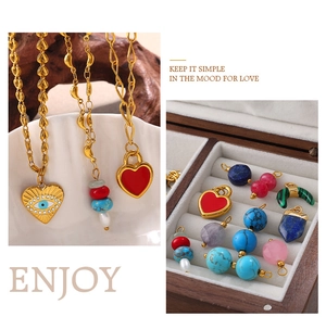 Detail of vintage 18K gold heart pendants with natural gemstones in a shell jewelry dish