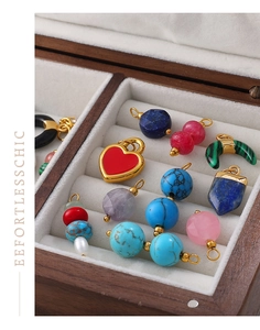 Detail of assorted gemstone heart and crescent charms in gold-plated settings