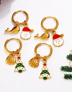 Dettaglio macro di orecchini placcati oro 18K con ciondoli natalizi in smalto