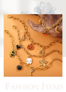 Detail van Halloween armband met vergulde pompoen- en schedelhangers aan de ketting