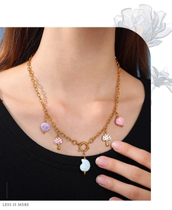 Model wearing 18K gold chain with colorful enamel mushroom and seashell pendants