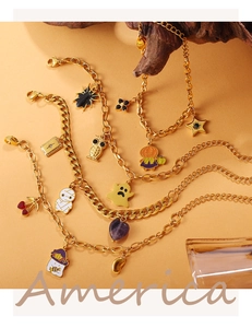 Detailopname van Halloween bedeltjes met spook en pompoen op een 18K vergulde armband